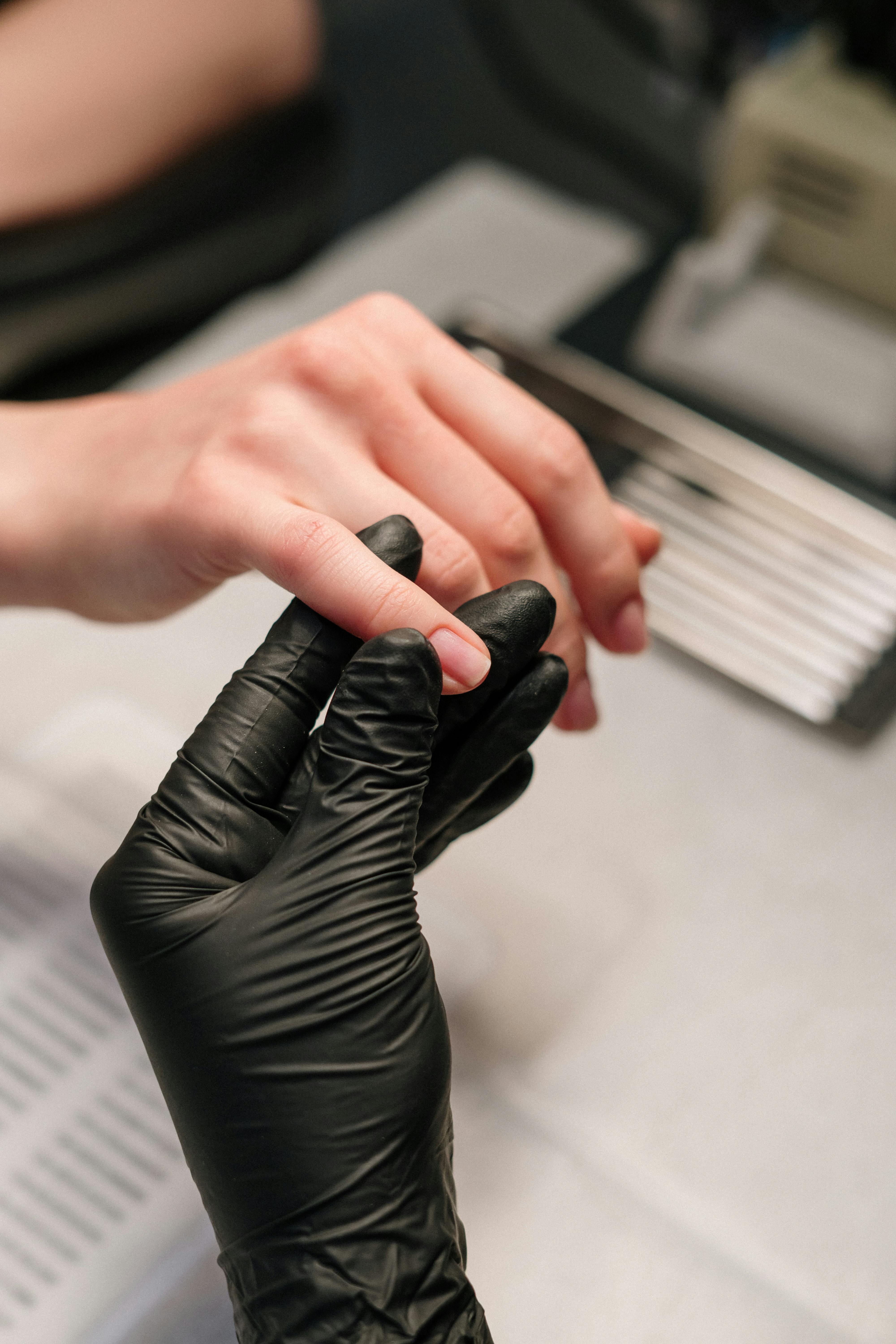 Person Wearing Black Gloves Making Nails
                  